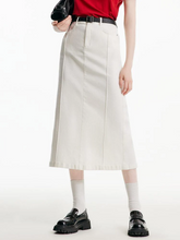 a lady wearing a white denim maxi skirt with belt